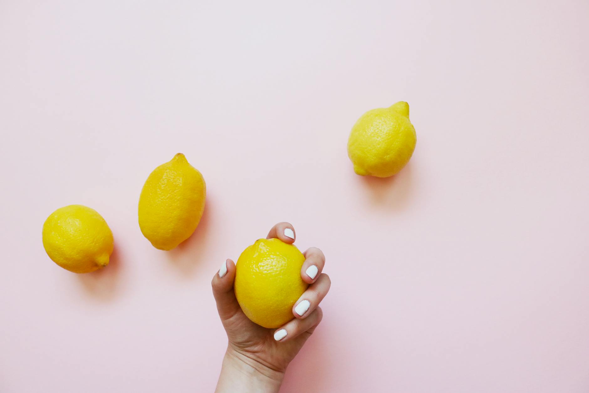 Fresh lemons on soft pink background representing lemon vibrators