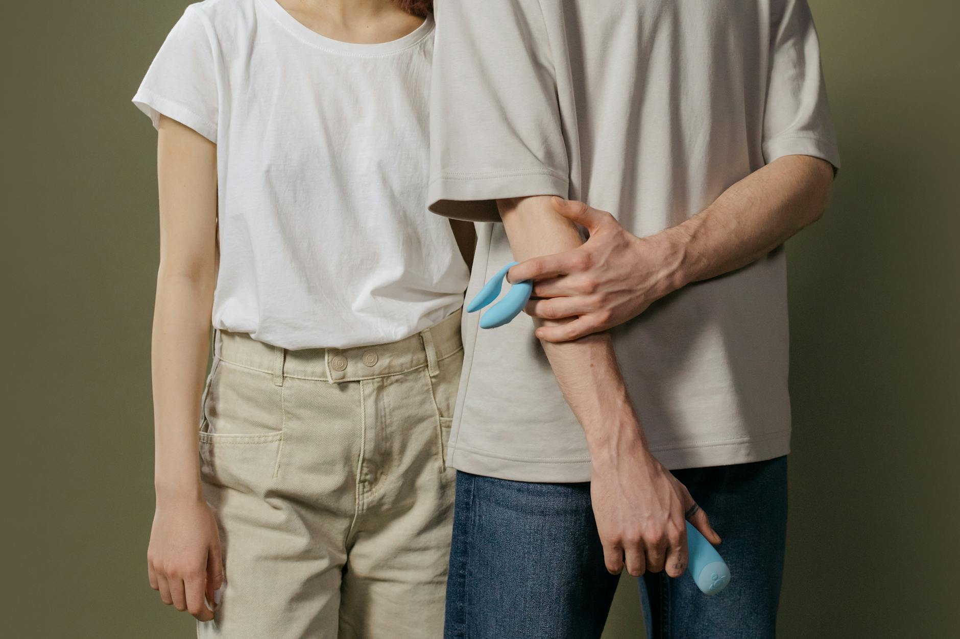 A couple standing together holding a vibrator, representing modern intimacy and partnership
